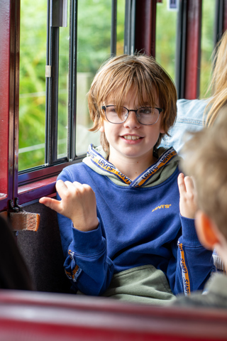 Boy sitting in a train carriage travelling to Wroxham station