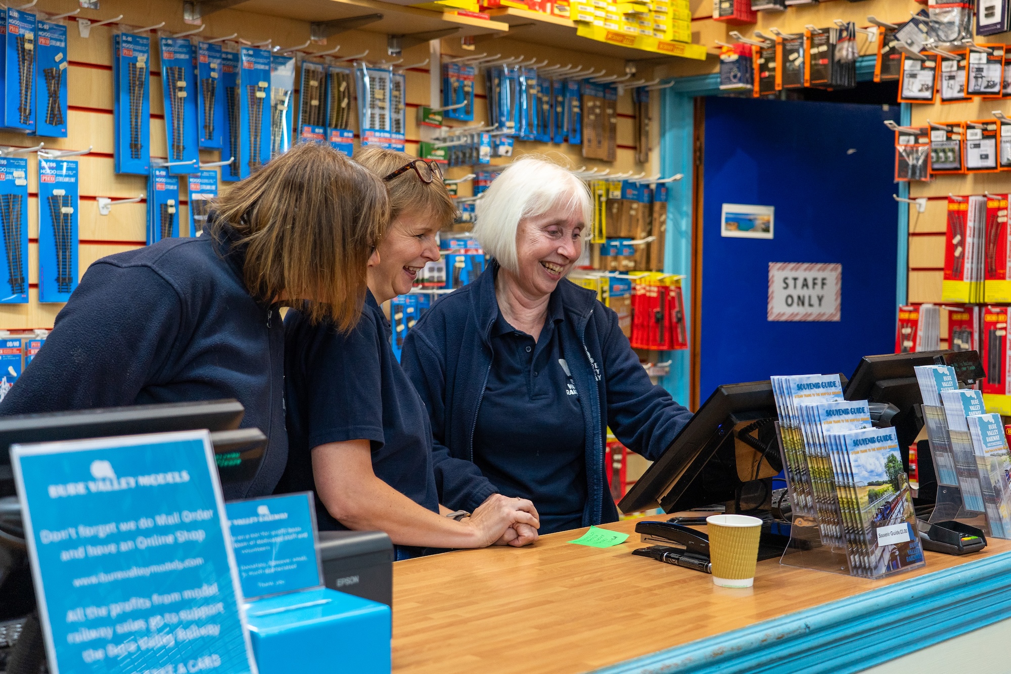 Staff Working Behind The Shop Counter