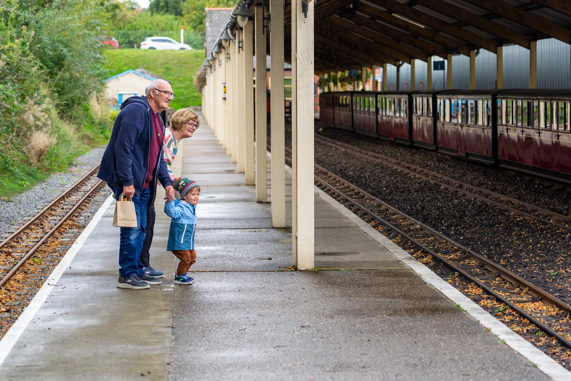Grandparents Watching Locomotives With Grandchild At Aylsham Station
