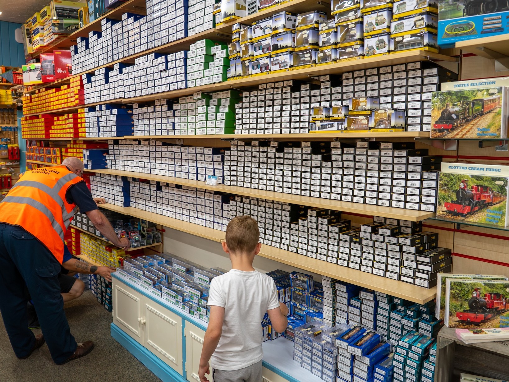 Little Boy Browsing Shelves Of Model Railway Stock
