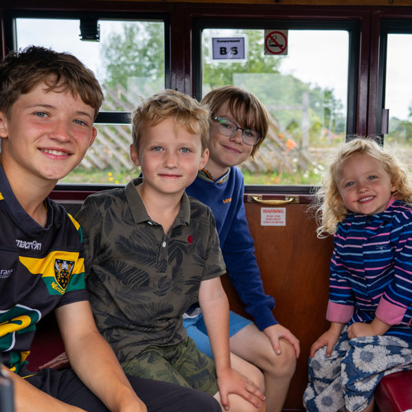 A group of children in a carriage ready to depart Wroxham Station